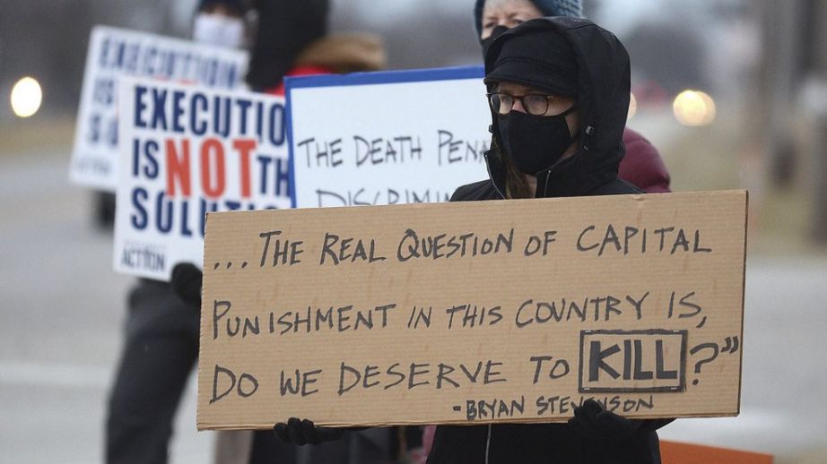 Christina Bollo of Urbana, Illinois, holds a sign as she protests