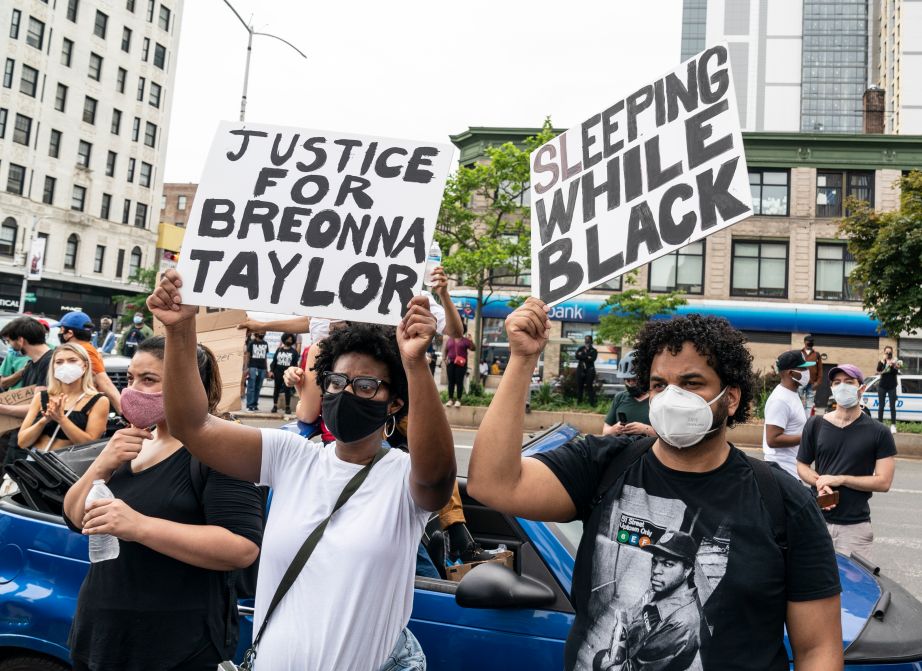 People holding signs Justice for Breonna Taylor Sleeping while Black