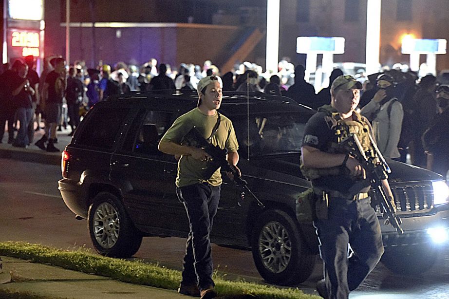 Kyle Rittenhouse, left, walks along Sheridan Road in Kenosha, Wis., with another armed civilian on Aug. 25