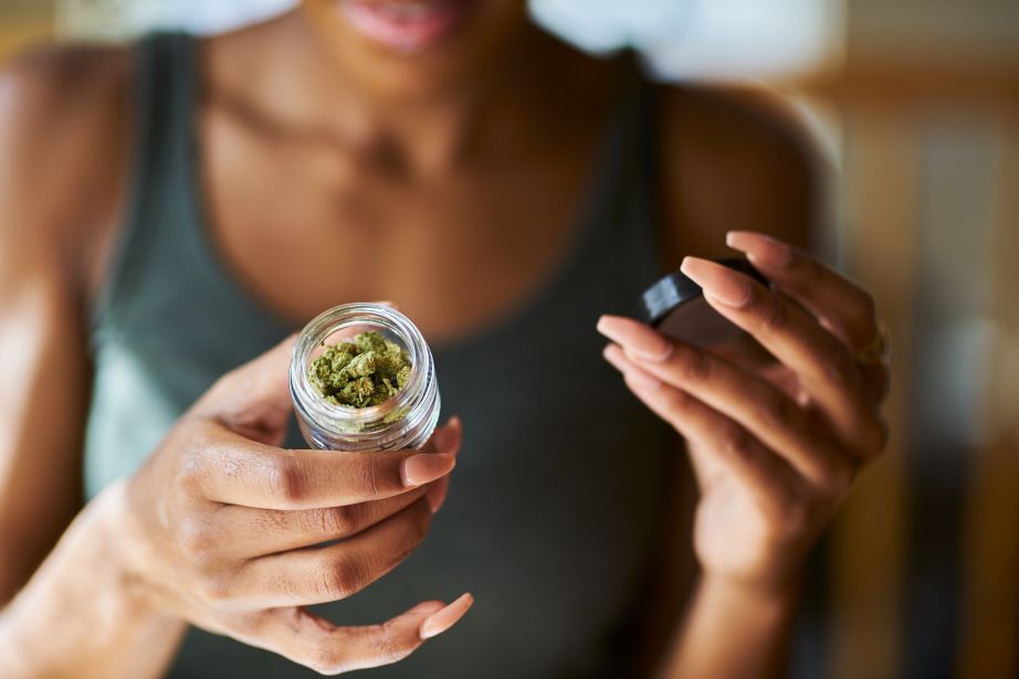 woman opening bottle of legal marijuana from dispensary close up