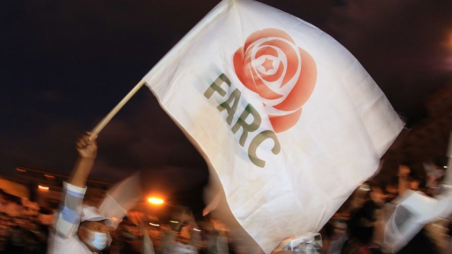 former FARC guerrilla member waves a FARC political party flag during a demonstration in Bogota