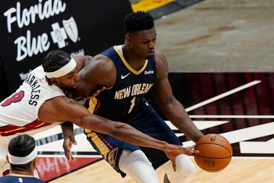 Miami Heat forward Moe Harkless, left, attempts to steal the ball from New Orleans Pelicans forward Zion Williamson