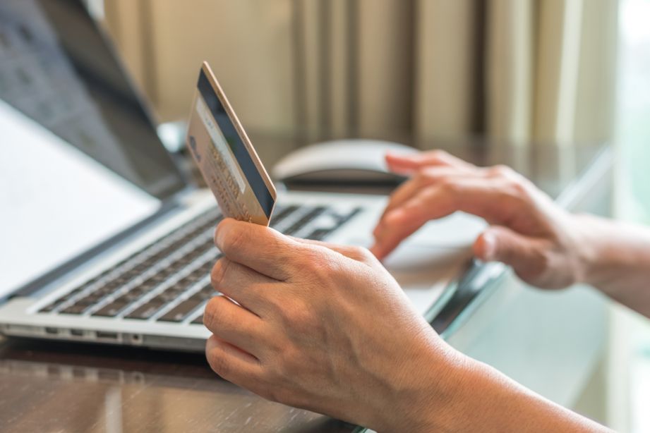 Man online shopping on computer with credit card