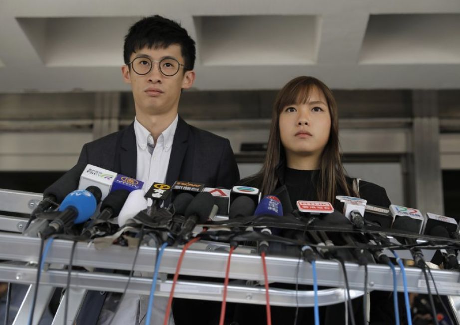 Former Hong Kong lawmakers Sixtus Leung, left, and Yau Wai-ching listen to reporters questions during a press conference outside the high court in Hong Kong, Wednesday, Nov. 30, 2016. (AP Photo/Vincent Yu)